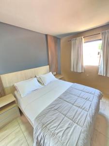 uma grande cama branca em um quarto com janela em HOTEL CARDINAL Pedro Juan Caballero em Pedro Juan Caballero