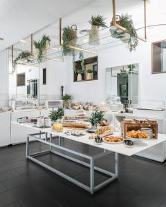 a kitchen with several tables filled with food at Hospes Puerta de Alcalá, a Member of Design Hotels in Madrid