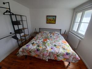 a bed with a floral comforter in a bedroom at Rösslerhof Ferienwohnung Obstwiese in Schlier-Unterankenreute