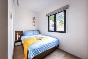 a small bedroom with a bed and a window at Lynn by La Doma Express in Ho Chi Minh City