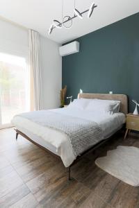 a bedroom with a large bed with a blue wall at LĀr - the Hidden Gem in Anatolí