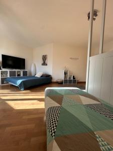 Un dormitorio con una cama y un televisor de pantalla plana. en Repos urbain, en Saint-Brieuc