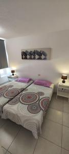 コスタ・アデヘにあるLa Statueの紫色の枕が付いた大きなベッドのある寝室