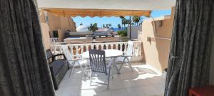 コスタ・アデヘにあるLa Statueのバルコニーにテーブルと椅子が置かれたパティオ