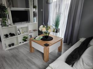 a living room with a coffee table with flowers on it at B&B Mooi Betuwe in Tiel