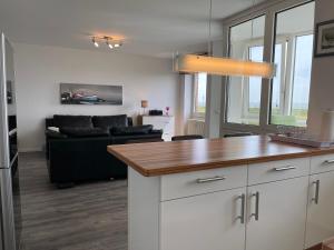 a kitchen and living room with a black couch at Apartment 12 in Wilhelmshaven