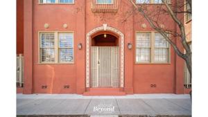 an orange building with a white door and windows at The Royal Treatment Downtown, Great for Travels in San Antonio