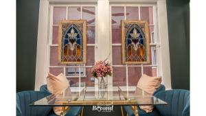 a glass table with a vase of flowers sitting in front of a window at The Royal Treatment Downtown, Great for Travels in San Antonio
