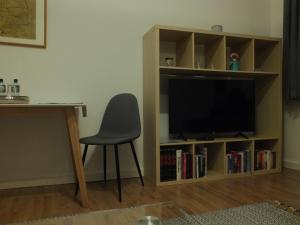 a room with a chair and a television in a book shelf at Fewo Augusta in Tangermünde
