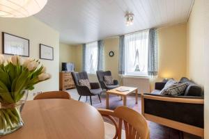 un soggiorno con tavolo, sedie e divano di Gartenhaus a Fehmarn