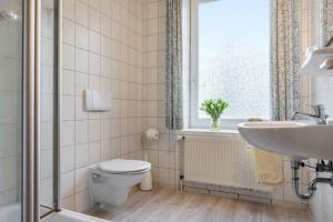 un bagno con un water, un lavandino e una finestra di Gartenhaus a Fehmarn