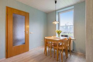 una sala da pranzo con tavolo, sedie e una finestra di Gartenhaus a Fehmarn