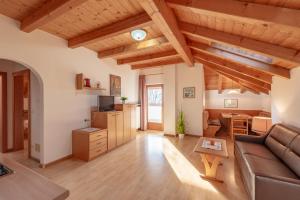 sala de estar con techos de madera y sofá en Apartments Haus Weinberg, en Pianizza di Sotto
