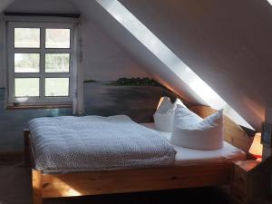 a bedroom with a bed with pillows and a window at kleine Herta in Prerow +8 photos