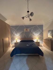 a bedroom with a blue bed and a chandelier at Sofi House in Santo Stefano di Camastra