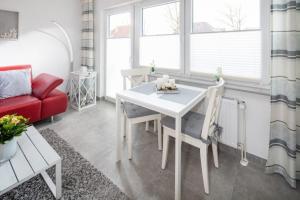 a living room with a table and a red couch at Admirals Lodge in Norddeich