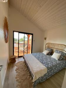 una camera da letto con un letto grande e un balcone di Comfortable holiday villa with spa a Lacanau