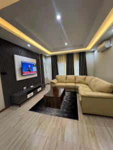 a living room with a couch and a flat screen tv at Meanwood Place Apartments in Lusaka