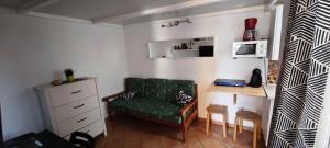 a living room with a green chair and a desk at Apartamentos en Castillo del Romeral in Castillo del Romeral