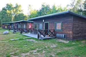 a small log cabin with a porch and a flag at Ferienhaus 4 Personen FH5 in Hindenberg +2 photos