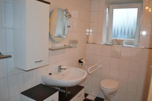 a white bathroom with a sink and a toilet at Wohnung "Amsterdam" in Heede
