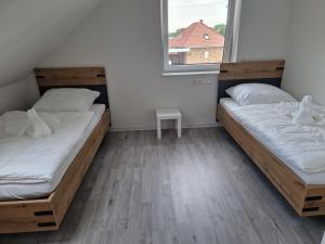 two beds in a room with a window at Wohnung 1 in Haselünne