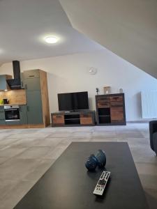 a living room with a television and a remote control at Wohnung 1 in Haselünne