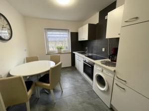 a kitchen with a table and a white refrigerator at Natalie in Münsingen