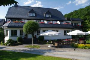 a large white building with umbrellas in front of it at Landhof Grewen Mühle in Meschede
