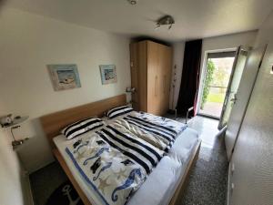 a bedroom with a bed with striped pillows on it at Kleine Auszeit in Dorum-Neufeld