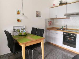 a kitchen with a wooden table and black chairs at Kleine Auszeit in Dorum-Neufeld