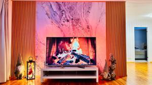 a living room with a tv with a fire in it at Willa Reindeer - komfortowy dom w sercu Laponii! in Pello