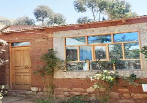 a brick house with a door and windows at Inti Raymi Lodge in Escallani