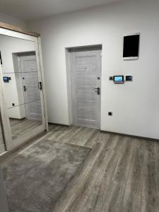 an empty room with two doors and a mirror at Apartmens MAMA in Sombor
