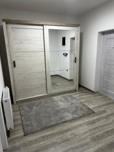 a room with a large wooden closet with a mirror at Apartmens MAMA in Sombor
