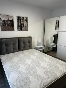 a bedroom with a bed and two mirrors at Apartmens MAMA in Sombor