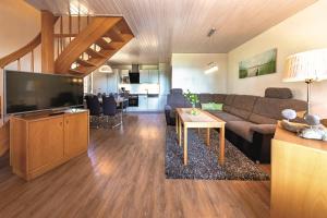 a living room with a couch and a tv at Ferienpark Heidenholz in Plau am See
