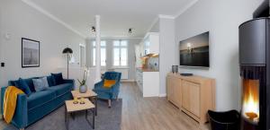 a living room with a blue couch and a tv at Villa Seeblick Kachliner See in Ahlbeck