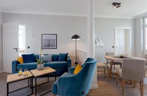 a living room with a blue couch and a table at Villa Seeblick Kachliner See in Ahlbeck