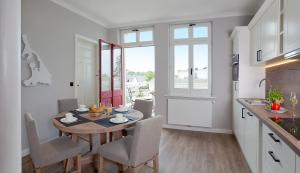 a kitchen and dining room with a table and chairs at Villa Seeblick Kachliner See in Ahlbeck