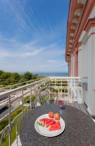 a plate of fruit sitting on a table on a balcony at Villa Seeblick Kachliner See in Ahlbeck