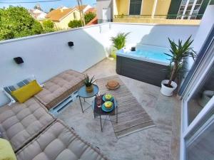 a balcony with a couch and a hot tub at Casa Lusitano by Valada Village in Valada
