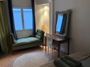 una stanza con una sedia, un tavolo e uno specchio di Charmante maisonnette a Troyes