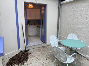 un patio con tavolo e sedie e una cucina di Charmante maisonnette a Troyes