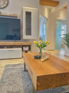 a living room with a wooden coffee table and a tv at Wohnung 3 Am Schlosspark in Bad Harzburg