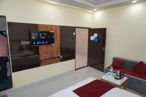 a room with a bed and a flat screen tv at Hotel Hanumat Palace-300 meter Jaipur junction & 1km Sindhi camp bus stand in Jaipur