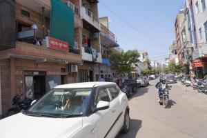 a white car parked on the side of a street at Hotel Hanumat Palace-300 meter Jaipur junction & 1km Sindhi camp bus stand in Jaipur