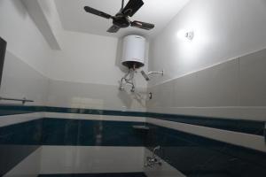 a bathroom with a ceiling fan and a toilet at Hotel Hanumat Palace-300 meter Jaipur junction & 1km Sindhi camp bus stand in Jaipur