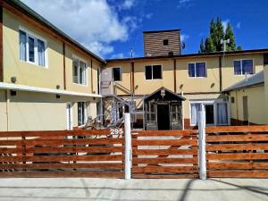 una valla de madera delante de una casa en Hostel Elal, en El Calafate