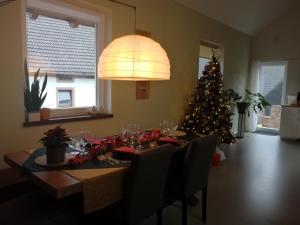 a dining room table with a christmas tree in the background at KyllHof Angelsen in Birresborn